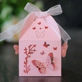 Pink laser-cut butterfly wedding favor box with elegant white ribbon tie on dark wood - Pink
