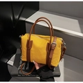 Détail d'un sac à main en toile jaune avec anses en cuir marron et fermeture éclair argent - Jaune