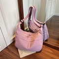 Fashionable dusty rose crescent crossbody bag with adjustable strap on wooden floor - Pink