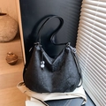 Black hobo shoulder bag featuring embossed floral patterns and a beaded charm detail - Black