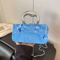 Blue marble texture acrylic handbag with silver metal handle held by a model - Blue