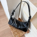 Close-up of black pebble grain leather hobo bag with silver butterfly heart charm detail - Black