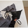 Detail of black textured bucket bag with white lace pearl bow and branding logo - With Charm / Black