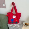 Red canvas tote bag featuring floral embroidery and side drawstring detail - Red