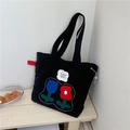 Black canvas tote bag with tulip embroidery and fearless pursuit of happiness text - Black