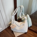 Chic beige hobo bag with cat embroidery and plush smiley charm in an indoor setting - Cream White With Pendant