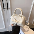 Creamy white bucket bag featuring a large bow detail and a silver heart pendant charm - White