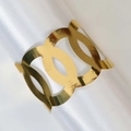 Détail d'un rond de serviette doré à cercles géométriques sur tissu en soie blanche - Or Réfléchissant