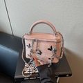 Pink box bag with metallic butterfly accents and a chain strap for crossbody wear - Pink