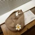 Bolso hobo tejido caqui con una margarita de punto en 3D sobre superficie madera - Caqui