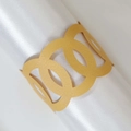 Gros plan sur un rond de serviette en papier doré avec motifs cercles ajourés - Or