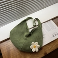 Bolso hobo tejido verde con detalle de margarita de ganchillo sobre superficie de madera - Verde