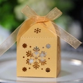 Detailansicht lasergeschnittener Schneeflocken auf einer goldenen Geschenkbox - Gold