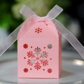 Nahaufnahme der rosa lasergeschnittenen Geschenkschachtel mit Schneeflocken und Organzaband - Rosa