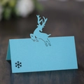 Macro detail of laser-cut reindeer seat card in light blue with snowflake design - Tiffany Blue