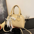 Chic beige litchi grain Boston handbag with pearl lace bow charm and silver hardware - Khaki