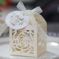 Close-up of laser-cut rose hollow candy box with ribbon and thank you tag on a plate - Jewelry Cream Star