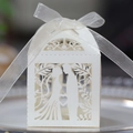 Macro detail of laser-cut white wedding favor box featuring bride and groom silhouette - Ivory