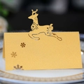 Detalle de tarjeta de mesa dorada con reno calado con láser para cena de Navidad - Dorado