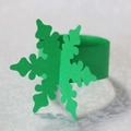 Close-up of green paper snowflake napkin ring on white textured fabric for festive table décor - Dark Green