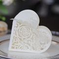 Macro detail of white heart-shaped candy box featuring laser-cut rose patterns and ribbon - Ivory