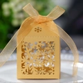 Detail einer warmgoldenen lasergeschnittenen Schneeflocken-Geschenkbox mit einer Organzaschleife - Gold