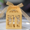 Dettaglio dell'intaglio laser a cuore e silhouette di coppia su scatola di nozze dorata - Oro