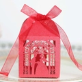 Close-up of laser-cut red wedding favor box with glitter texture and ribbon bow - Pearlescent Red
