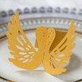 Detailed laser-cut golden swan napkin ring with intricate hollow wing patterns on white plate - Gold