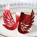 Macro shot of red laser-cut swan napkin ring with metallic hollow texture on ceramic plate - Reflective Bright Red