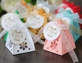 Detailed view of pyramid candy boxes with snowflake cutouts and elegant ribbon bows - With Tag Style
