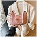 Pink pleated hobo bag with bow and pearl lace charm accessory held against white suit - Pink with Pendant
