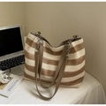 Detail der gewebten Stroh-Tote-Bag mit braunen Ledergriffen und Ketten-Details aus Metall - Khaki