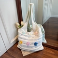 White hand-knitted tote bag featuring colorful crochet flowers and hollow-out patterns - White