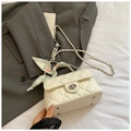 Close-up of white quilted crossbody bag with silk scarf handle and silver metal lock - White