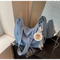 Close-up of blue denim hobo bag with adjustable strap and cute cartoon capybara charm - Blue with Charm