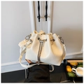 Close-up of cream drawstring bucket bag with pleated texture and pearl charm detail - White with Pendant
