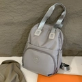Light grey nylon backpack for women featuring large front pocket and silver straps - Gray