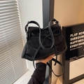 Détail d'un sac à bandoulière en cuir mat noir avec nœud et ferrures argentées élégantes - Noir