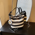 Striped woven bucket bag with black leather straps and smiley flower charm accent - Black with Pendant