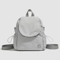 Dettaglio zaino grigio chiaro impermeabile con trama increspata e logo circolare scuro - Grigio