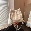 White quilted bucket bag with chain strap and Clear K metal logo in soft lighting - White