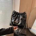 Black quilted bucket bag with gold chain strap and metallic logo detail - Black