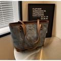 Detail van de blauwe canvas shopper met bruine leren bies en gouden metalen accenten - Blauw