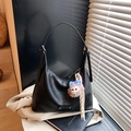 Borsa sottobraccio in pelle nera minimalista con orsetto su blazer beige e libro - Con Ciondolo / Nero
