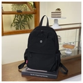 Detail of minimalist black nylon backpack with durable side mesh pocket and logo label - Black