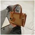 Detail view of contrast stitching handbag with brown leather strap and horse charm - Brown