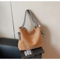 Close-up of woven straw tote bag with black and white striped ribbon bow details - Brown