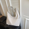 Large beige nylon tote bag with functional side pocket on a black leather bench - White