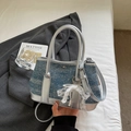 Denim blue and silver bucket bag with white lace bow charm on bed background - Denim Blue With Pendant